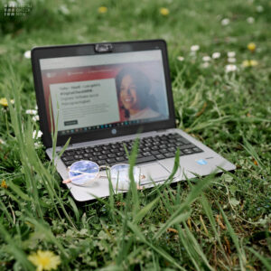 Offener Laptop steht auf einer Blumenwiese. Auf dem Bildschirm ist doe Startseite von www.digitalcheck.nrw geöffnet.
